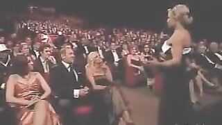 Pamela Anderson and Trish Stratus kiss during an awards show in 2006.